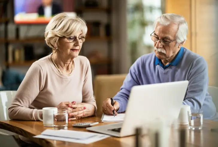 Retire couple reviewing bank savings documents